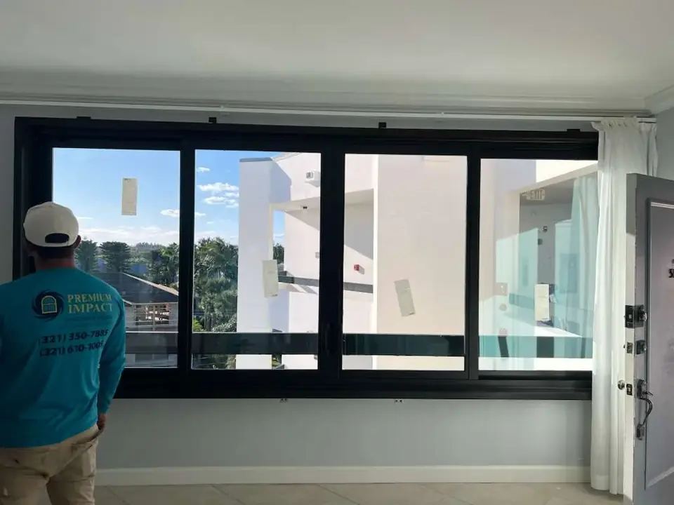 Black-frame impact window wall with a water view